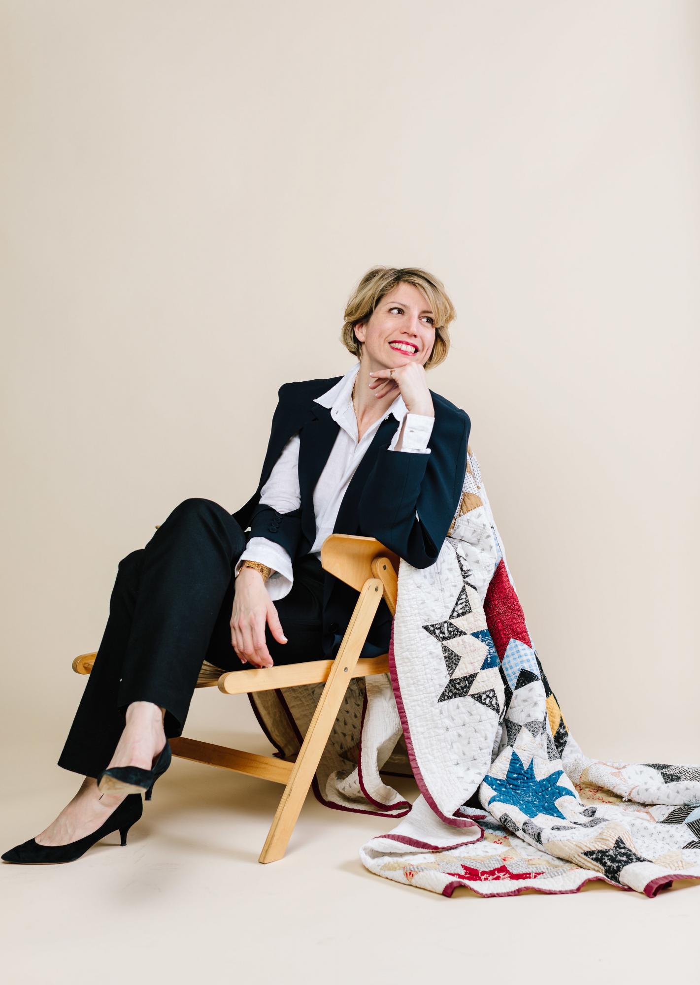 Guest speaker Mary Fons seated with a quilt.