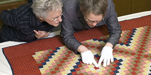 People inspecting a quilt
